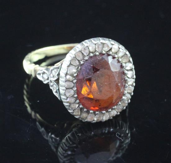 An early 19th century gold and silver, hessonite garnet and diamond cluster ring, size J.